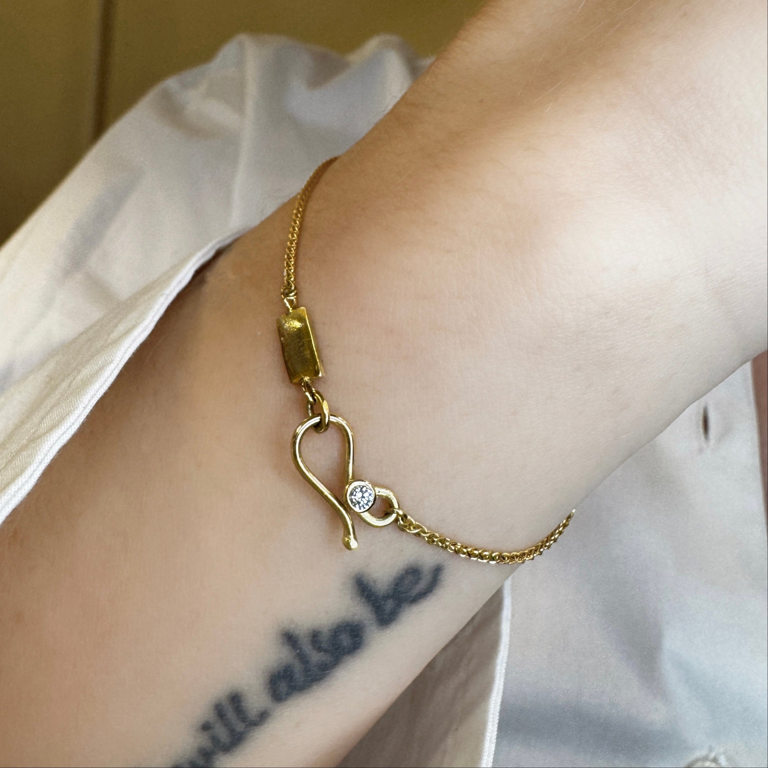 Armbånd med lille hammerslået plade og diamant på lås