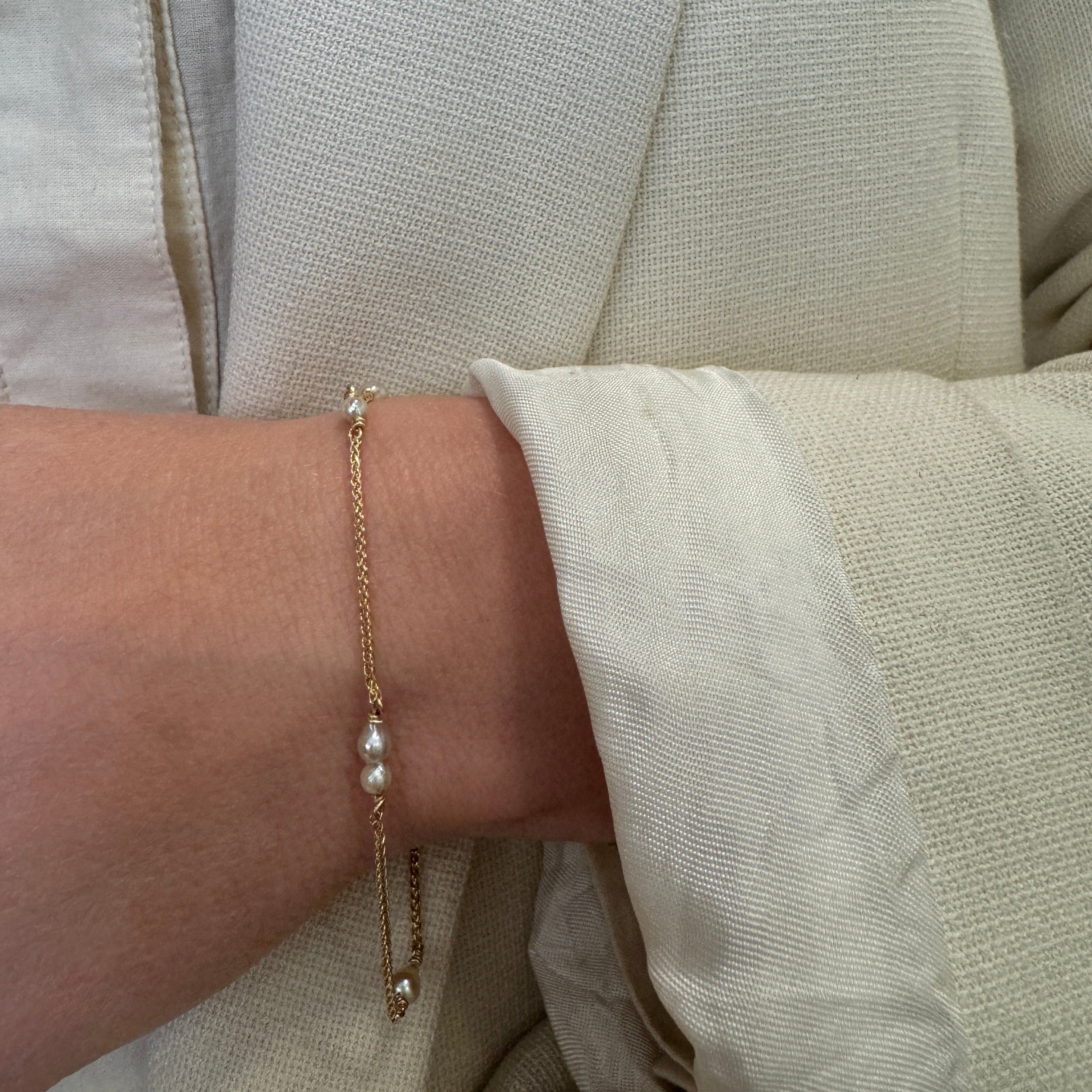 Armbånd i 18 karat guld med små lyse Akoya perler