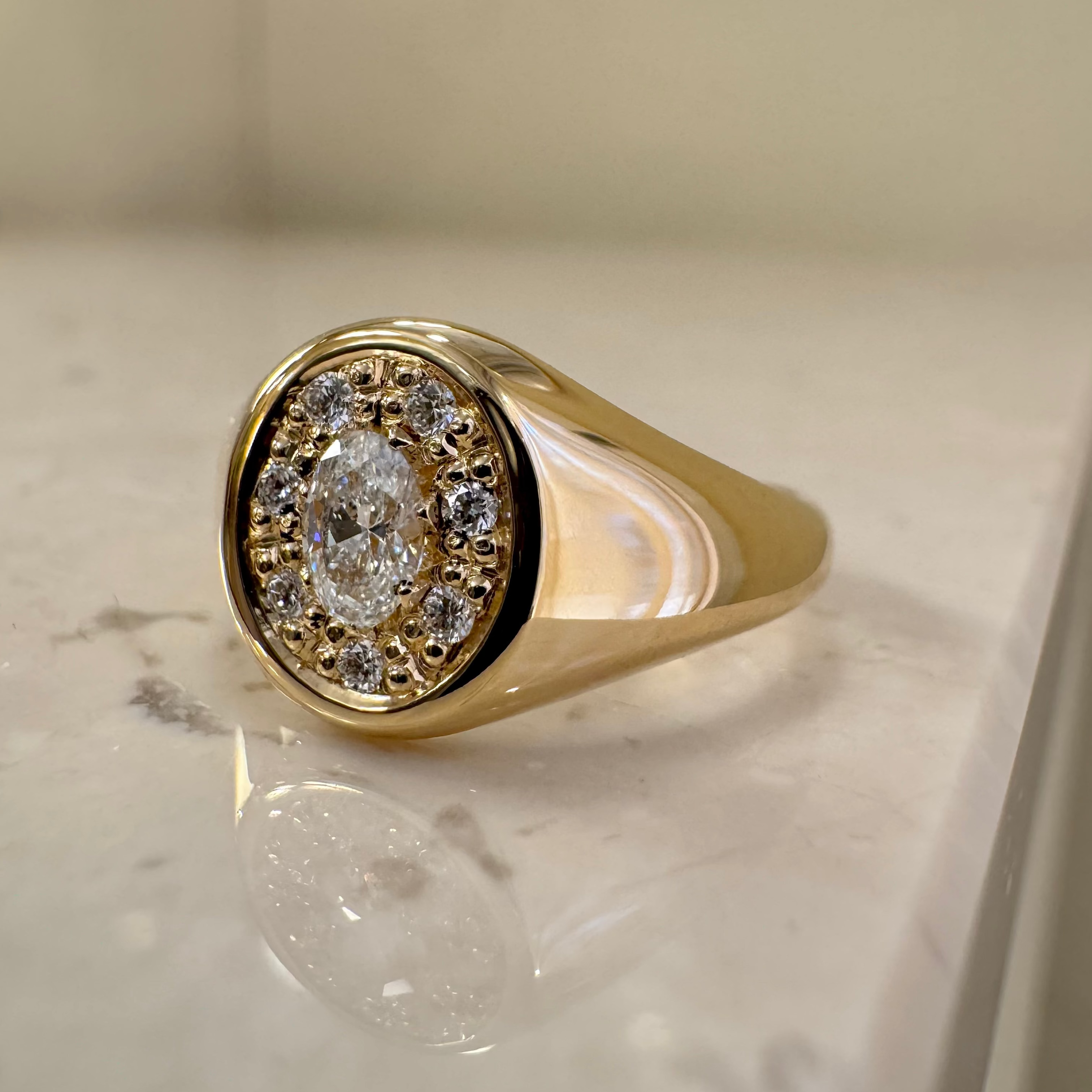 Oval signetring med oval diamant og syv små runde, 18 karat guld