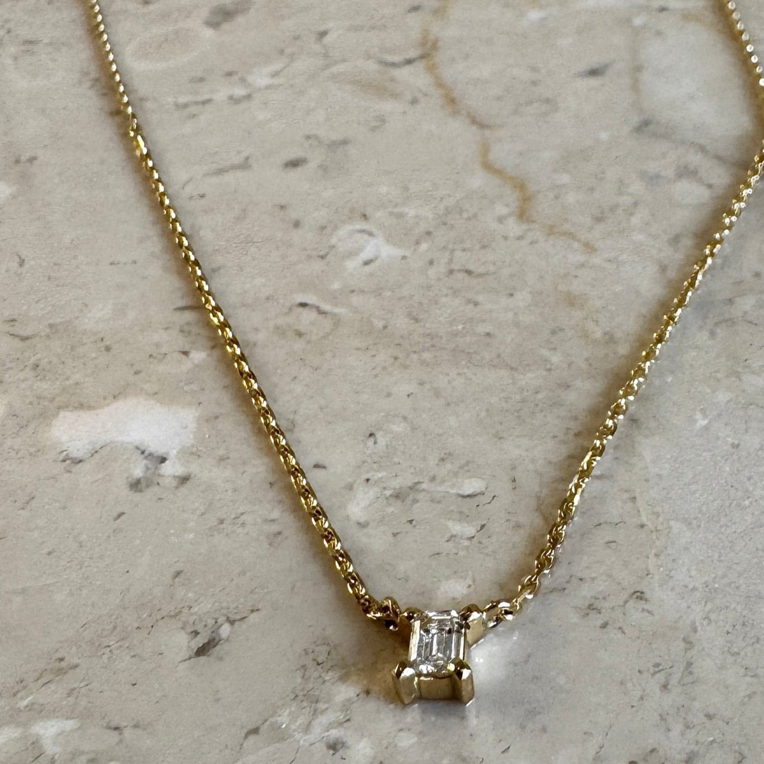 solitair diamantkæde i 18 karat guld med emerald cut hvid diamant