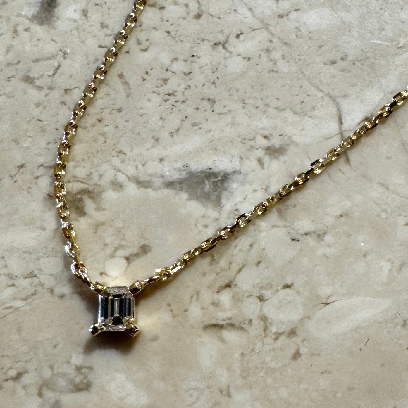 solitair diamantkæde i 18 karat guld med emerald cut hvid diamant