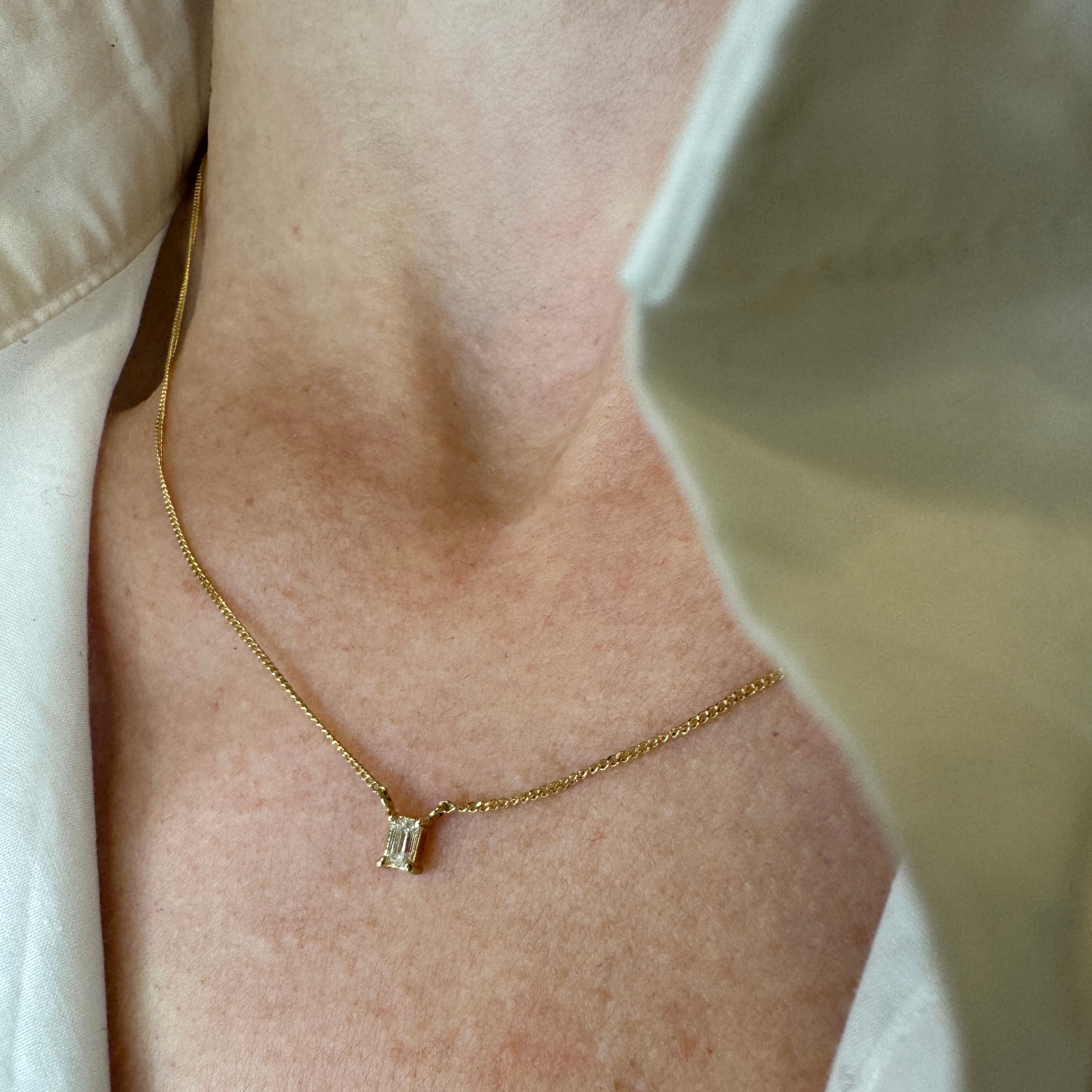 solitair diamantkæde i 18 karat guld med emerald cut hvid diamant