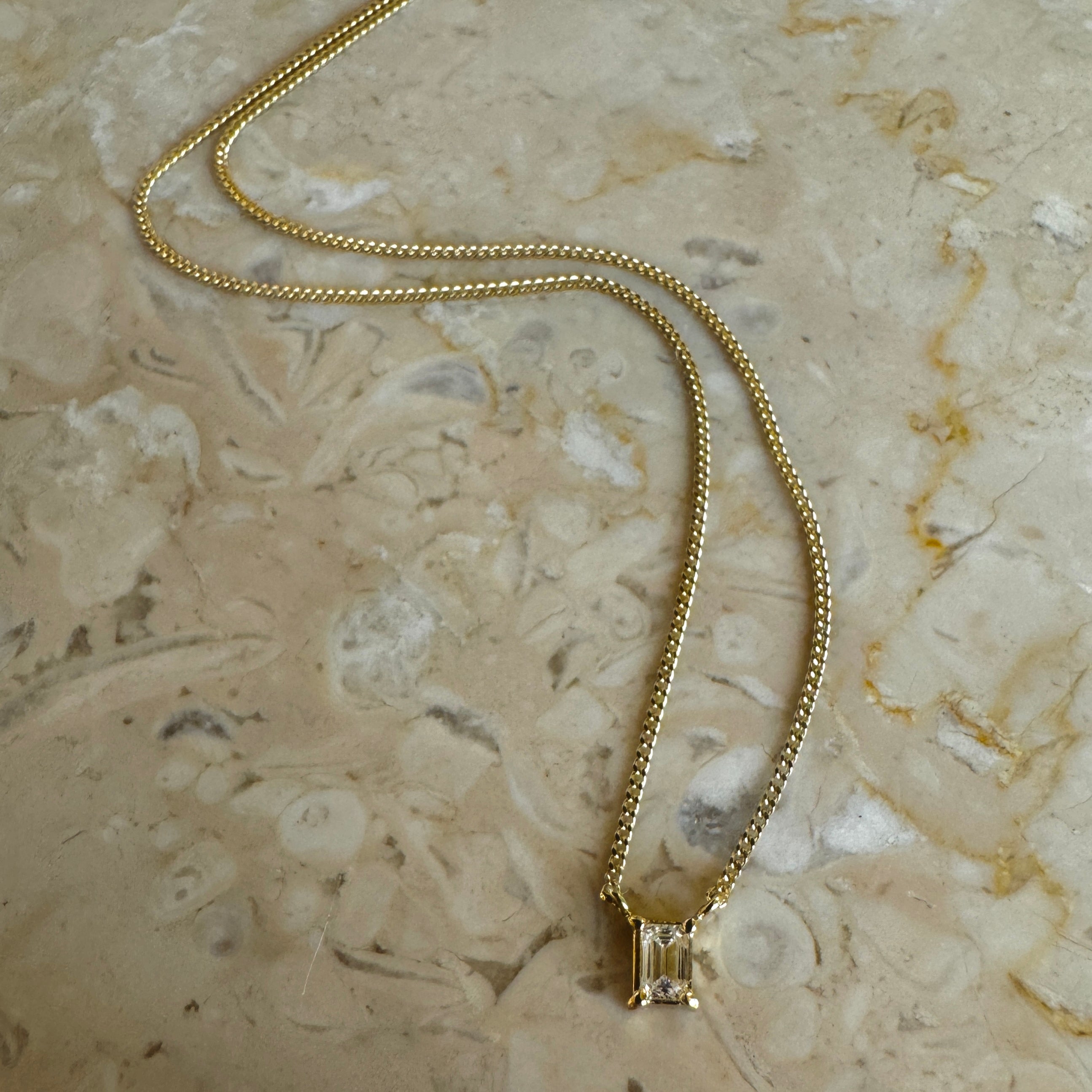 solitair diamantkæde i 18 karat guld med emerald cut hvid diamant