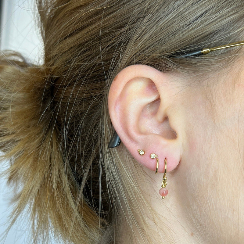 Dobbeltdrejet øreringe med lyserøde opaler